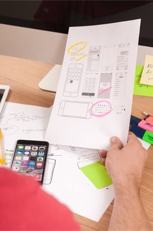 création d'un ID wireframes dessinés sur écran et papier illustrant la conception d’une expérience utilisateur fluide et centrée sur l’utilisateur